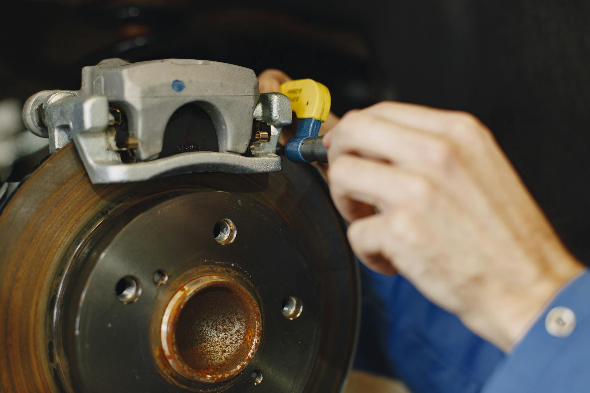 Close-up of disc brake rotor and caliper being serviced