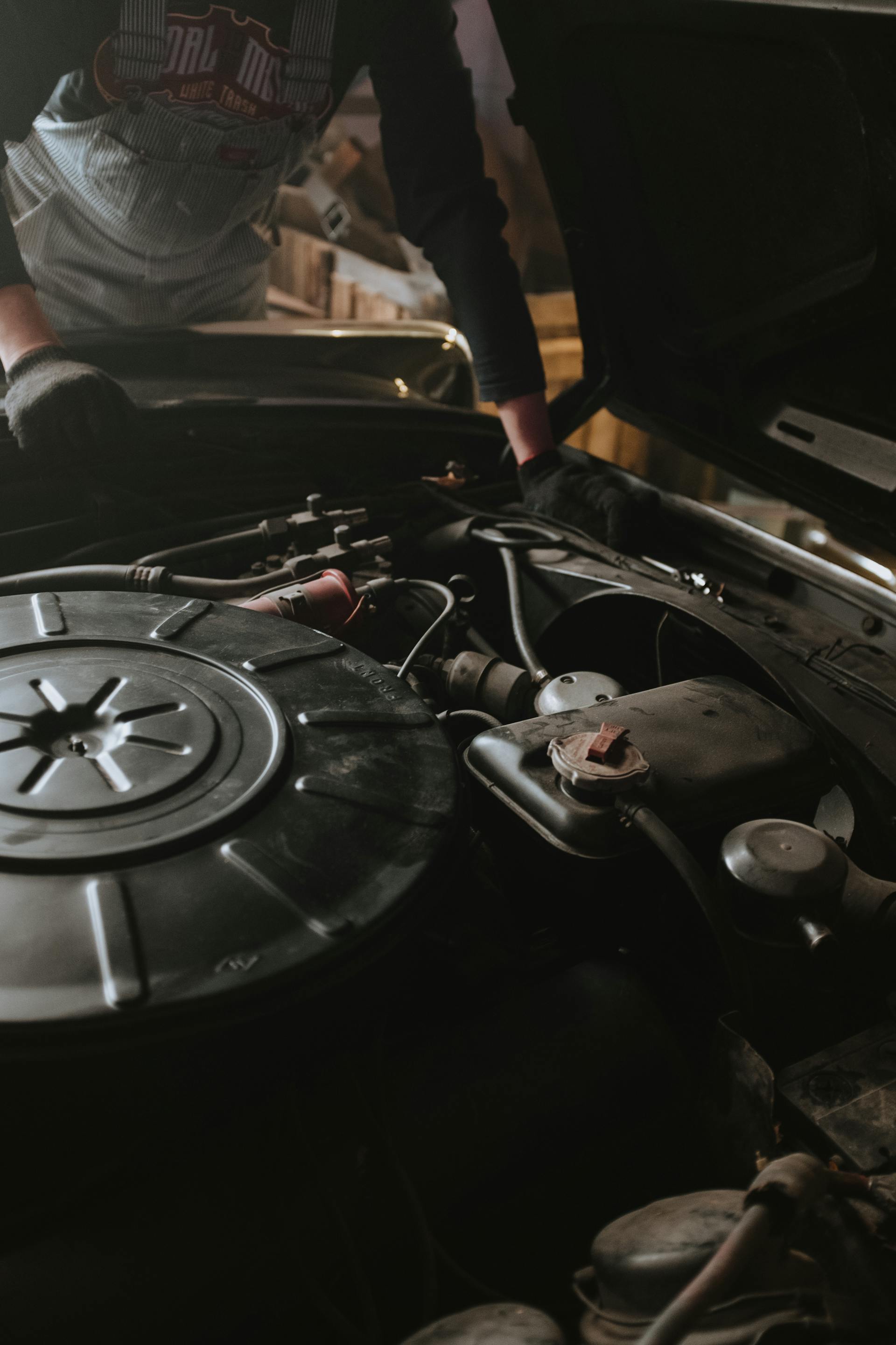Mechanic performing engine diagnostics under the hood