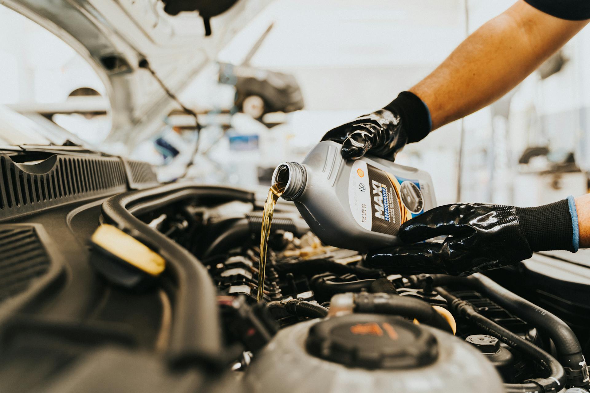 Mechanic pouring transmission fluid during service